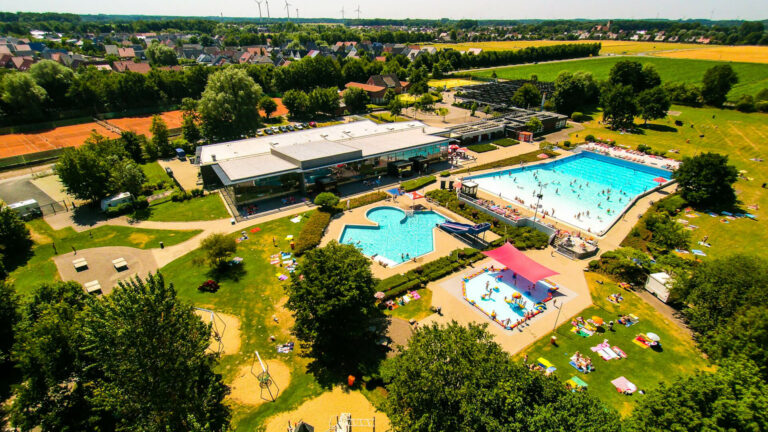 Luftaufnahme des Freibads in Ahaus mit mehreren Schwimmbecken, Liegewiesen und umliegenden Bäumen