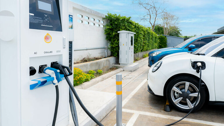 Weißes Elektroauto, das an einer Ladestation im Freien aufgeladen wird