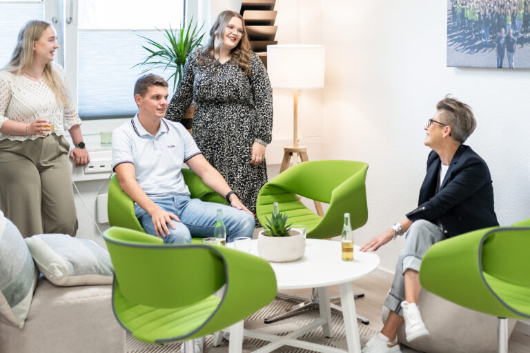Vier LokalWerke Mitarbeiter/innen unterhalten sich in einem modernen Büro