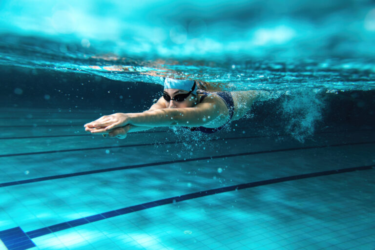 Sportliche Schwimmerin taucht im Schwimmerbecken
