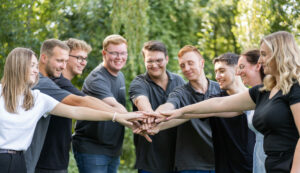 neun Azubis legen ihre Hände übereinander
